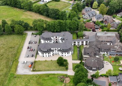 Ansicht des Hauses und der grünen Umgebung von oben mit einer Drohne aufgenommen.