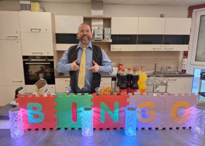 Ein Mitarbeiter steht hinter einem gebastelten Bingo Schild