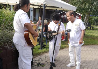 Mitarbeiter singen und musizieren beim Sommerfest